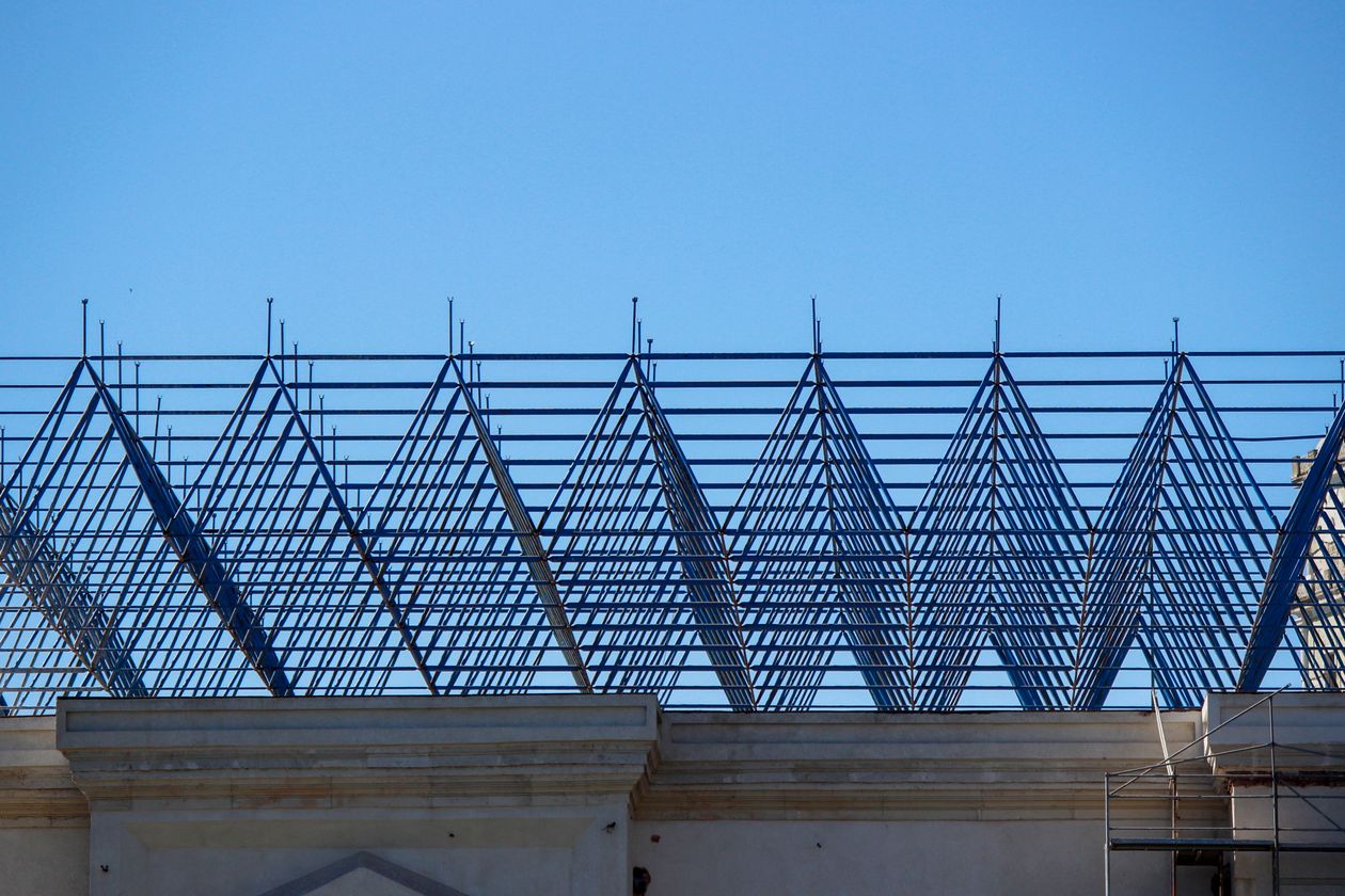 Steel roof trusses against a clear blue sky