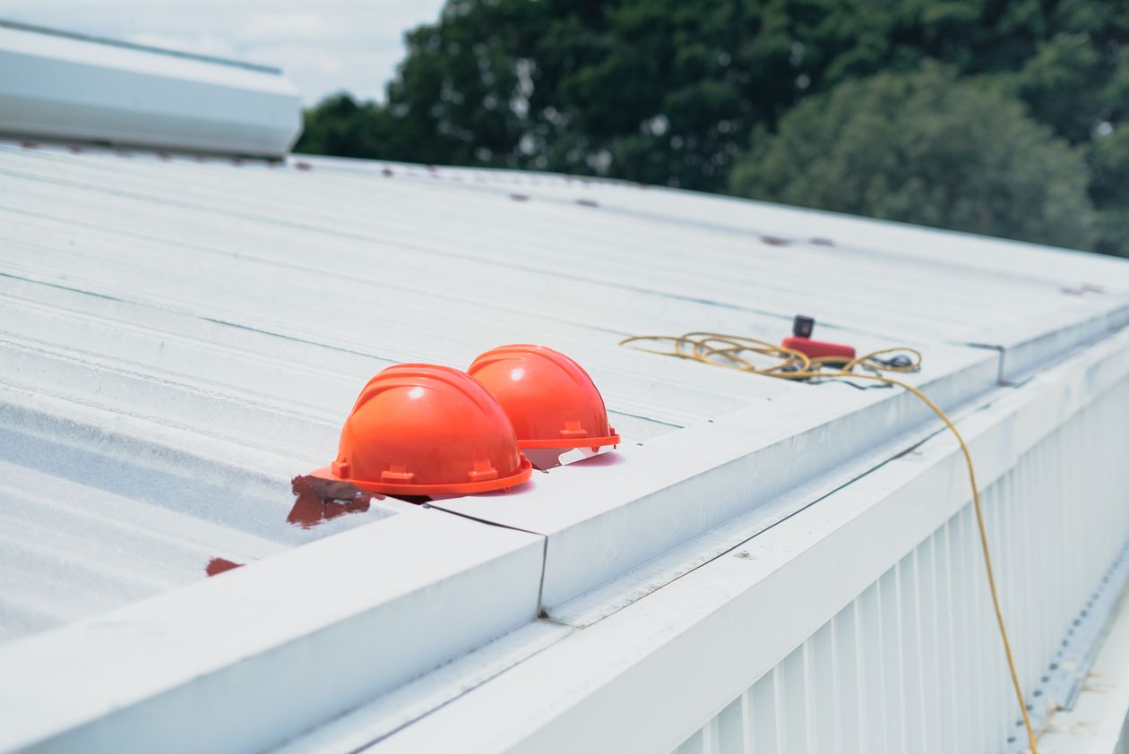 Two hard hats resting on a finished metal roof